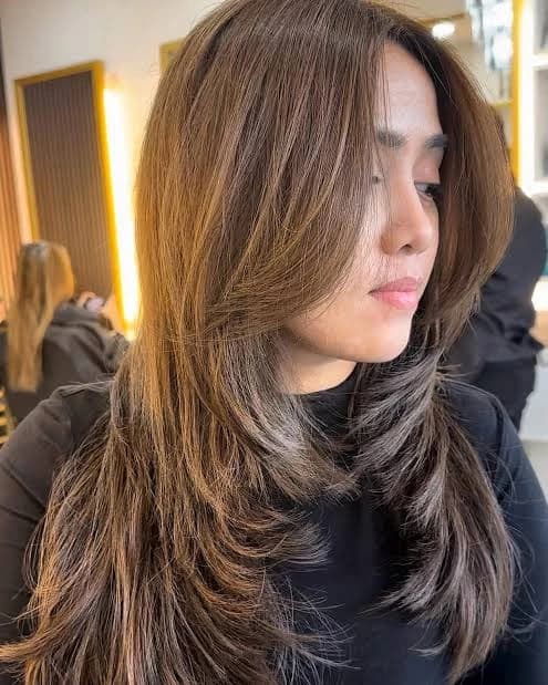 Side profile of layered hair with warm highlights